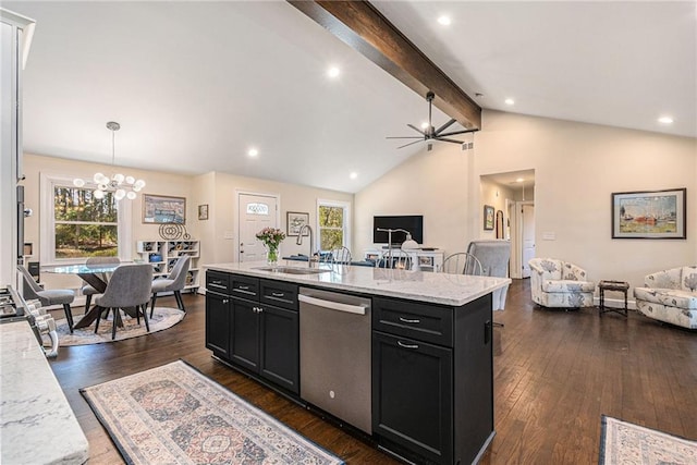 kitchen with dishwasher, open floor plan, vaulted ceiling with beams, dark cabinetry, and a sink