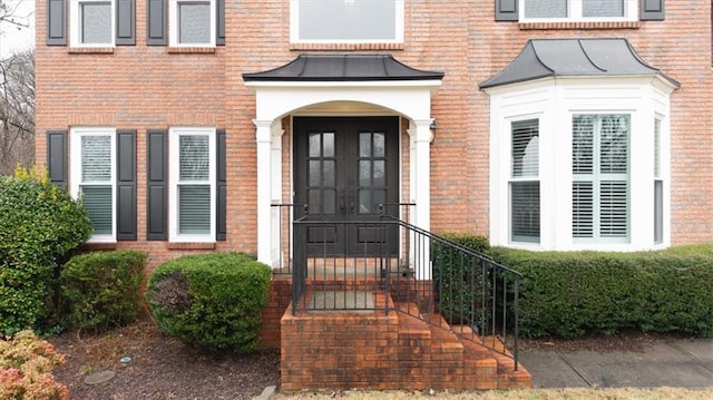 entrance to property featuring a standing seam roof, metal roof, and brick siding