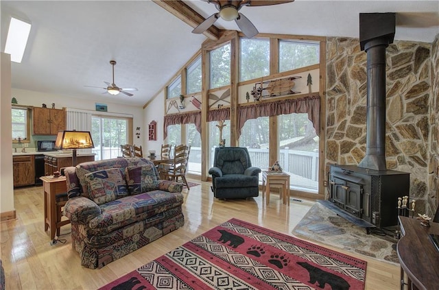 214 S View Trl, Jasper, GA 30143 - living area featuring a ceiling fan, a wood stove, light wood-style floors, high vaulted ceiling, and beamed ceiling