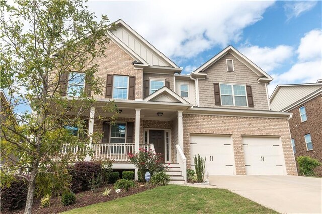 570 Eldridge Dr, Suwanee, GA 30024 - craftsman house with a garage, covered porch, concrete driveway, and brick siding