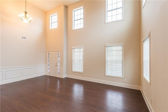 570 Eldridge Dr, Suwanee, GA 30024 - interior space with dark wood-style flooring, an inviting chandelier, baseboards, a towering ceiling, and visible vents