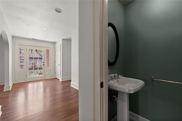 bathroom with a sink, baseboards, and wood finished floors