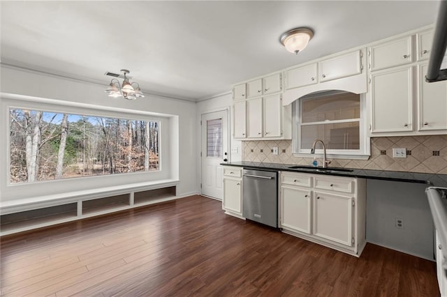 kitchen with a sink, dark countertops, dishwasher, and dark wood finished floors