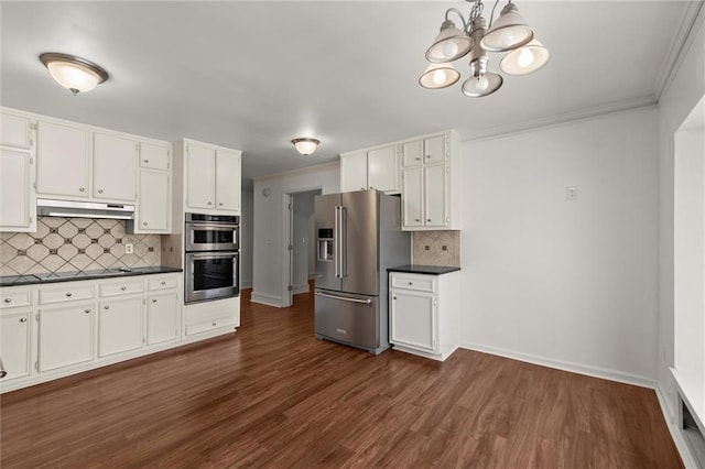 kitchen featuring ornamental molding, stainless steel appliances, white cabinets, under cabinet range hood, and dark countertops