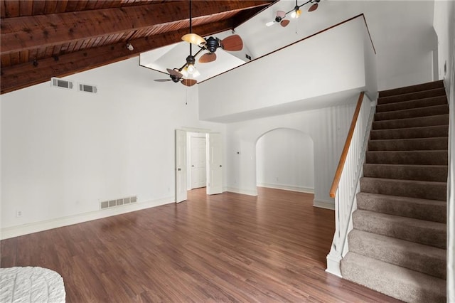 unfurnished living room with stairs, visible vents, arched walkways, and a ceiling fan