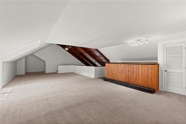 bonus room with light carpet and vaulted ceiling