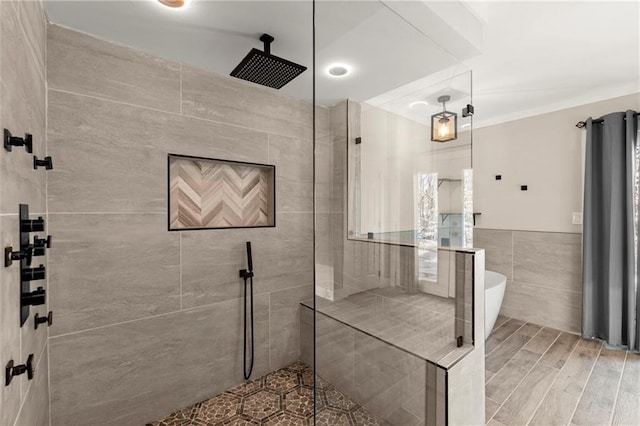 bathroom with tile walls, a freestanding tub, wood tiled floor, and walk in shower