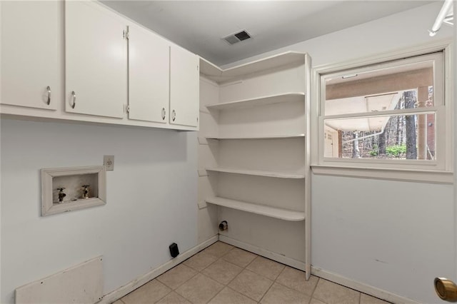 laundry area featuring visible vents, baseboards, washer hookup, light tile patterned floors, and cabinet space