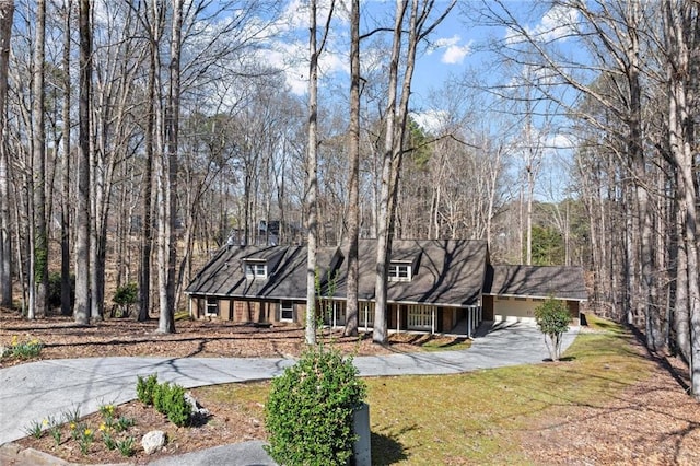 rear view of house with aphalt driveway, a yard, a garage, and a porch