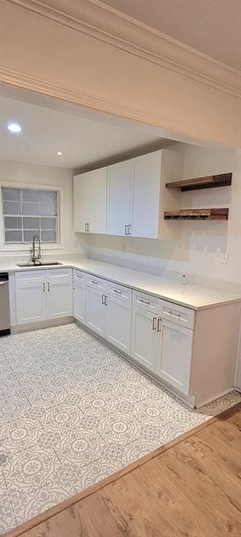 kitchen with crown molding, light hardwood / wood-style floors, sink, and white cabinets