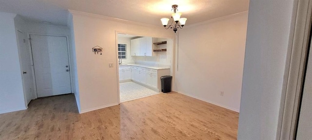 interior space featuring a notable chandelier, light hardwood / wood-style flooring, and ornamental molding