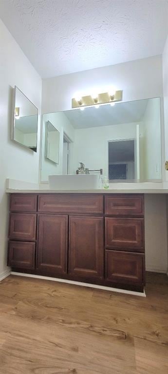 bathroom with wood-type flooring, sink, and a textured ceiling