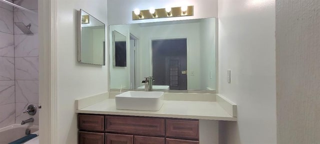 bathroom with tiled shower / bath combo and vanity