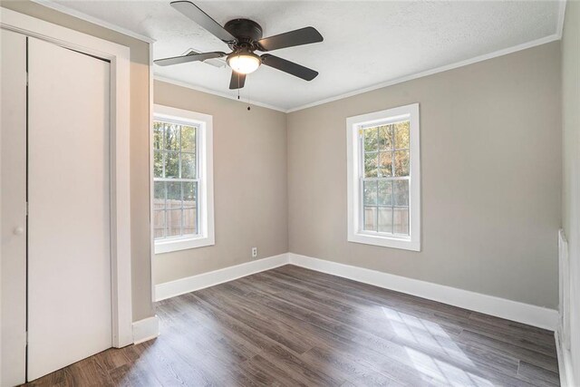 unfurnished bedroom with dark wood-type flooring, ceiling fan, and ornamental molding