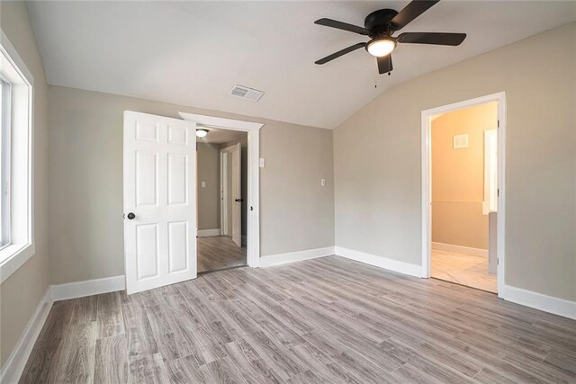 unfurnished bedroom featuring ceiling fan, vaulted ceiling, and light hardwood / wood-style flooring