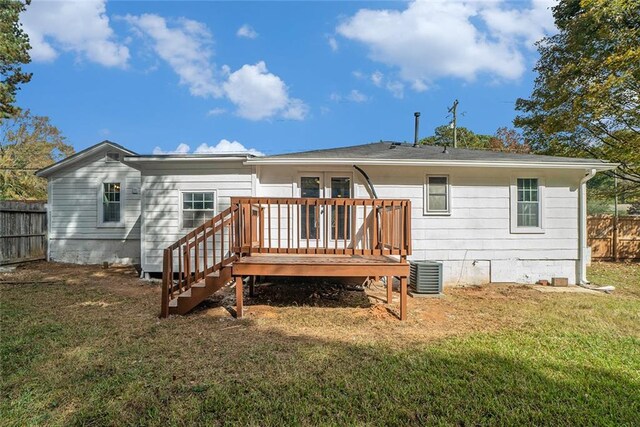 back of property with cooling unit, a deck, and a yard