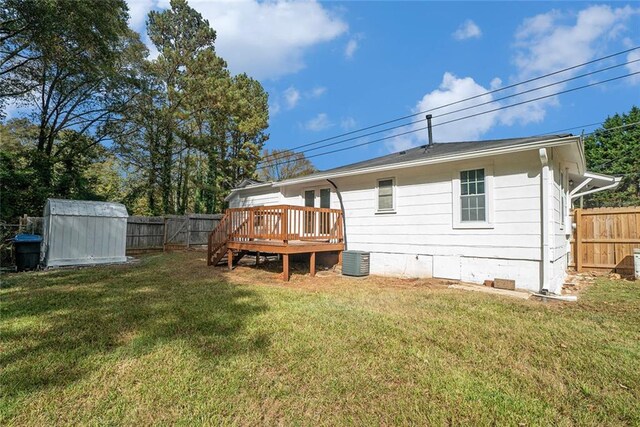 back of property featuring a yard, a shed, a wooden deck, and cooling unit