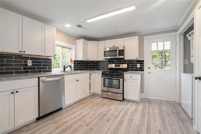 kitchen with white cabinetry, appliances with stainless steel finishes, and a wealth of natural light