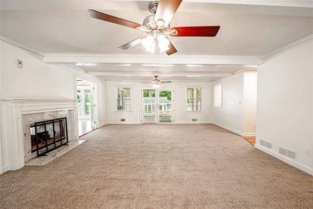 unfurnished living room with ceiling fan, crown molding, a premium fireplace, and plenty of natural light