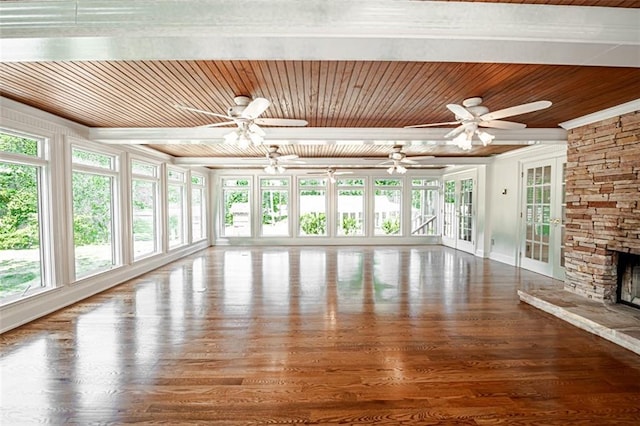 unfurnished living room featuring ceiling fan, a stone fireplace, and a healthy amount of sunlight