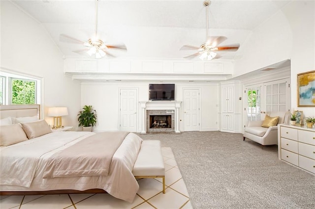 carpeted bedroom with high vaulted ceiling, a premium fireplace, and ceiling fan