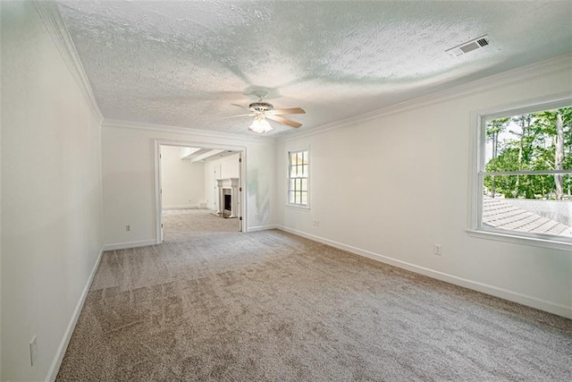 carpeted spare room with ceiling fan, a textured ceiling, and ornamental molding