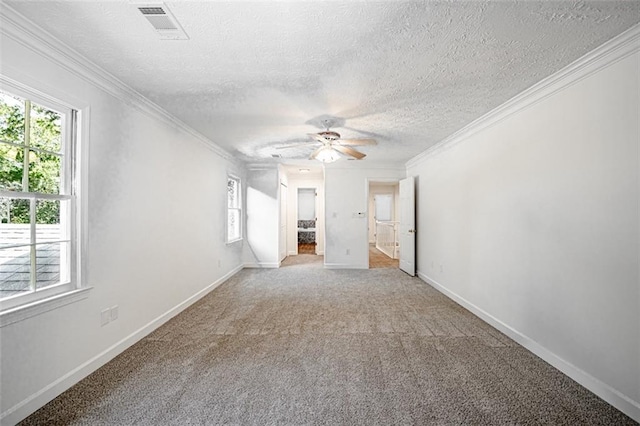 interior space with a textured ceiling, carpet, ceiling fan, and crown molding