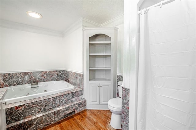 bathroom with a textured ceiling, hardwood / wood-style flooring, tiled tub, crown molding, and toilet