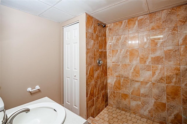 bathroom featuring vanity, tile patterned flooring, toilet, and tiled shower