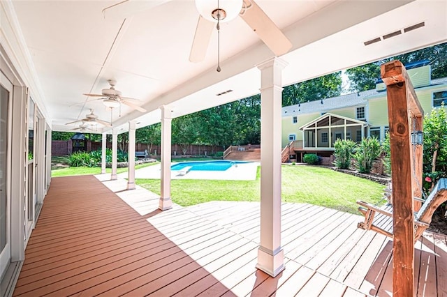 deck featuring a yard, ceiling fan, and a fenced in pool