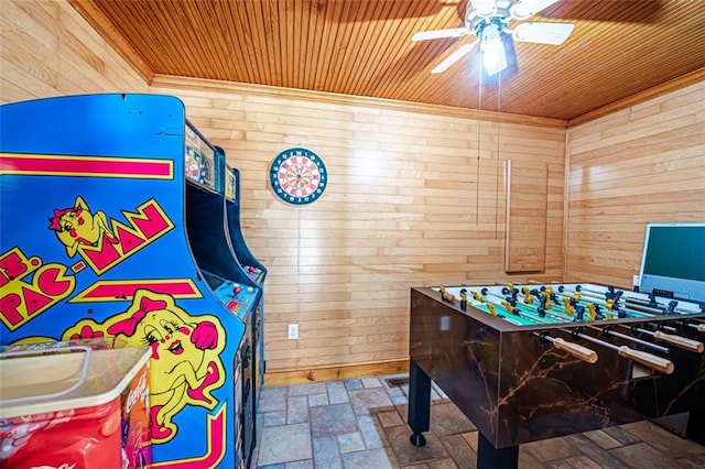 game room featuring wood ceiling, wooden walls, and ceiling fan