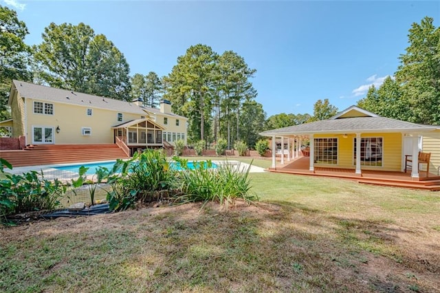 view of yard with a sunroom and a swimming pool side deck