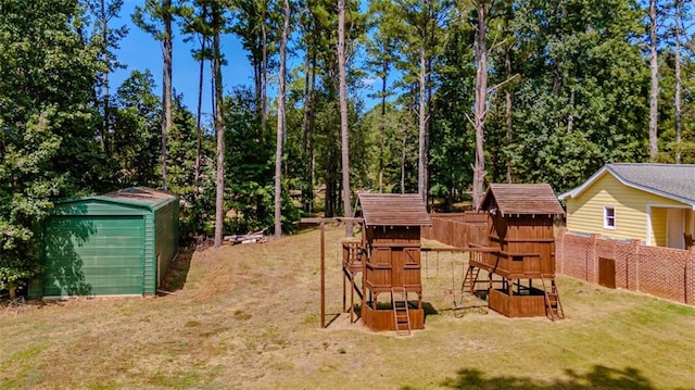 view of yard with a storage shed and a playground