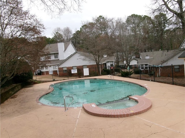 community pool featuring fence and a patio