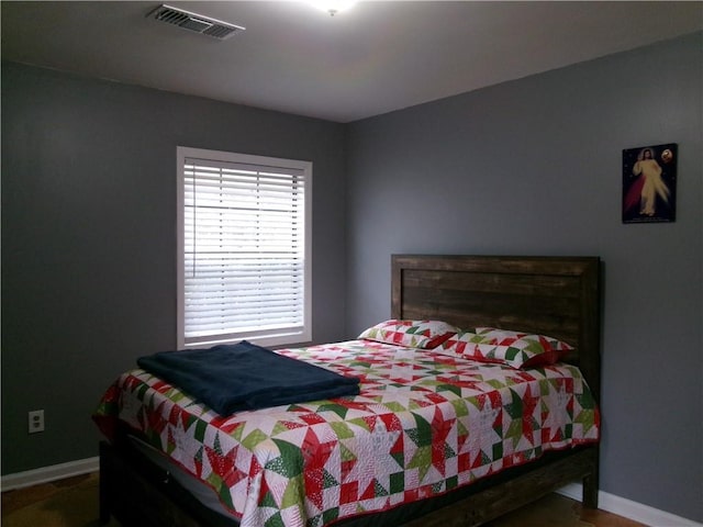 bedroom featuring baseboards and visible vents