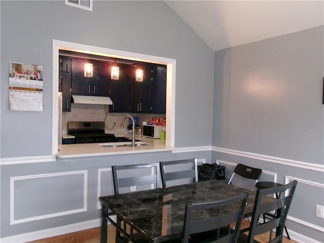 dining space with lofted ceiling and visible vents