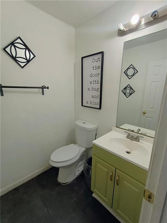 bathroom featuring tile patterned floors, vanity, and toilet