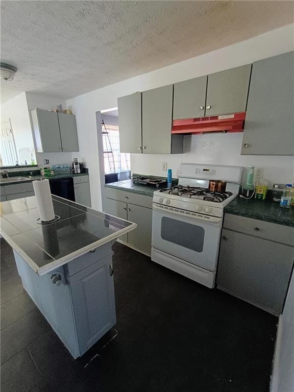 kitchen featuring a kitchen breakfast bar, gas range gas stove, and a textured ceiling