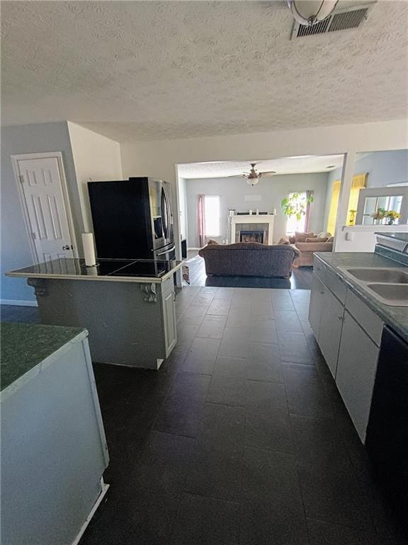 kitchen featuring sink, white cabinets, a textured ceiling, and black appliances