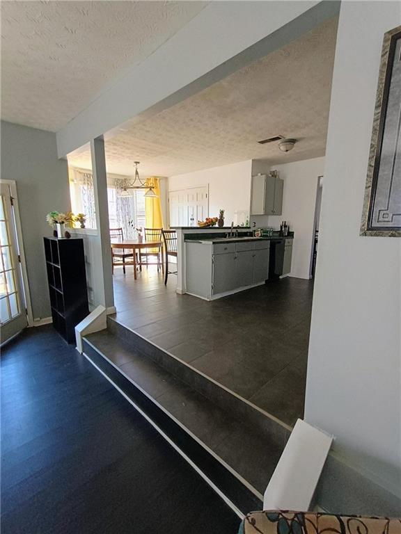 interior space with sink, a notable chandelier, and a textured ceiling