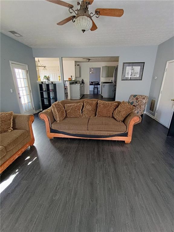 living room featuring dark hardwood / wood-style flooring and ceiling fan