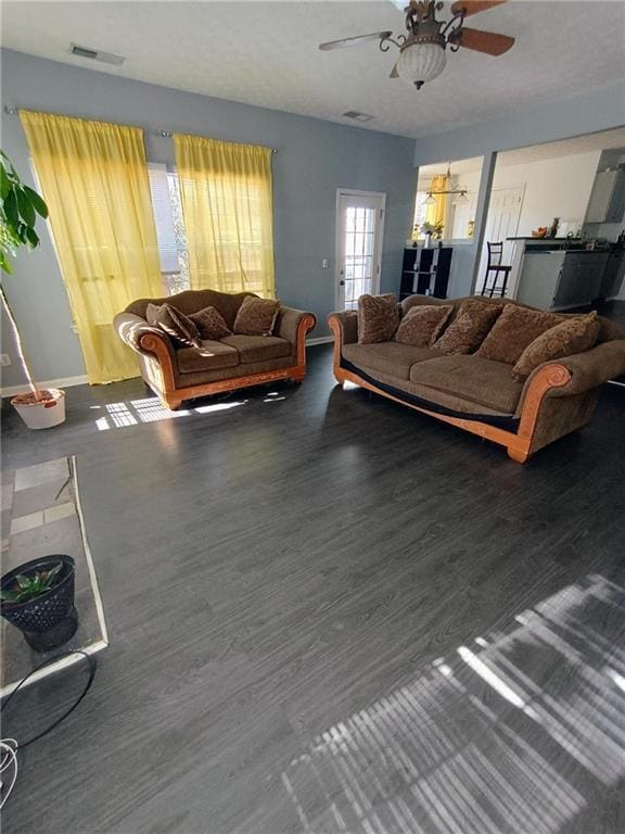 living room featuring ceiling fan and dark hardwood / wood-style floors