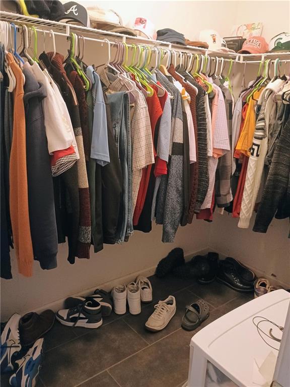 spacious closet featuring dark tile patterned floors