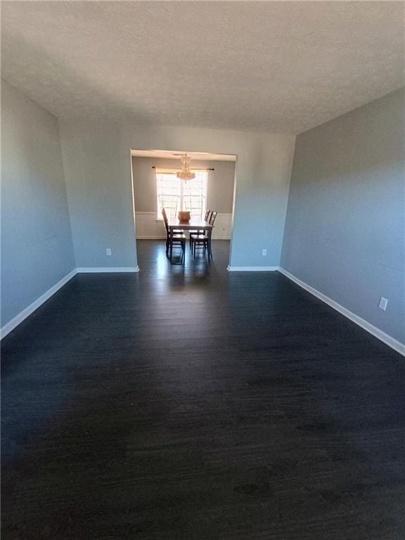 unfurnished room with dark hardwood / wood-style floors and a textured ceiling