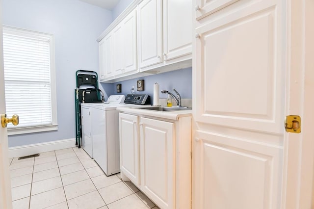 clothes washing area with cabinets, light tile patterned flooring, washer and dryer, and sink