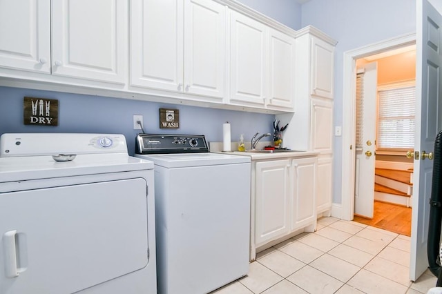 laundry area with cabinets, washing machine and dryer, sink, and light tile patterned floors