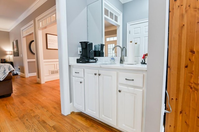 bathroom featuring hardwood / wood-style flooring, crown molding, and vanity