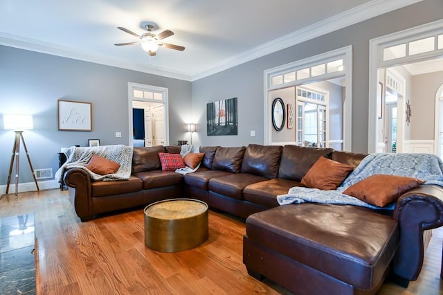 living room featuring hardwood / wood-style flooring, crown molding, and ceiling fan