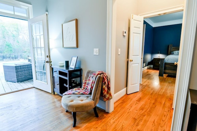 interior space with french doors, ornamental molding, and light hardwood / wood-style flooring