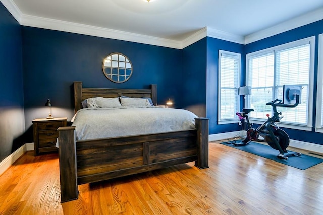 bedroom featuring crown molding and light hardwood / wood-style flooring